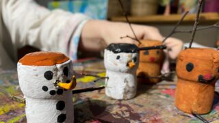 Kinderhand malt / bastelt einen Schneemann