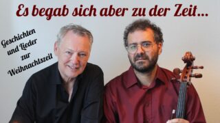 Zwei Männer der eine hat ein Cello in der Hand mit dem Spruch "Es begab sich aber zu der Zeit"
